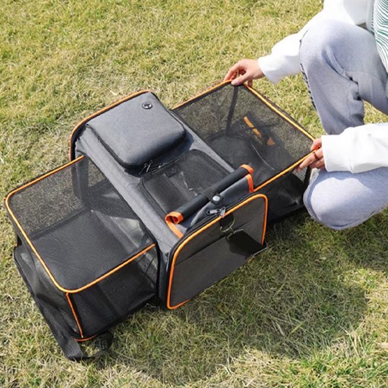Sac transport pour chien orange ouvert en enclos sur pelouse
