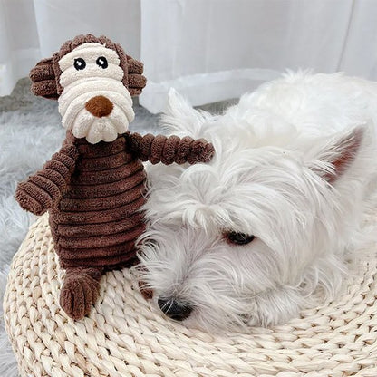 chien blanccouch près de Peluche pour chien  sur moquette