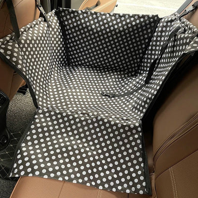 siège auto chien noir pois sur banquette de voiture